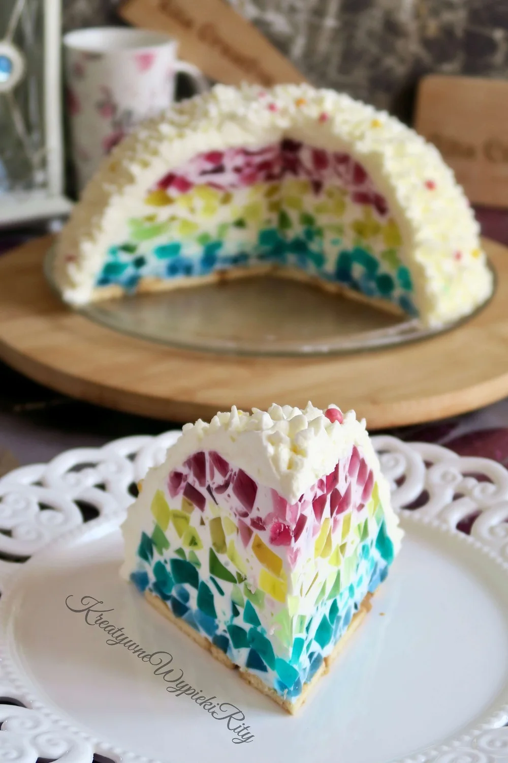 Kawałek sernika na zimno z kolorowymi galaretkami w środku i puszystą masą serową