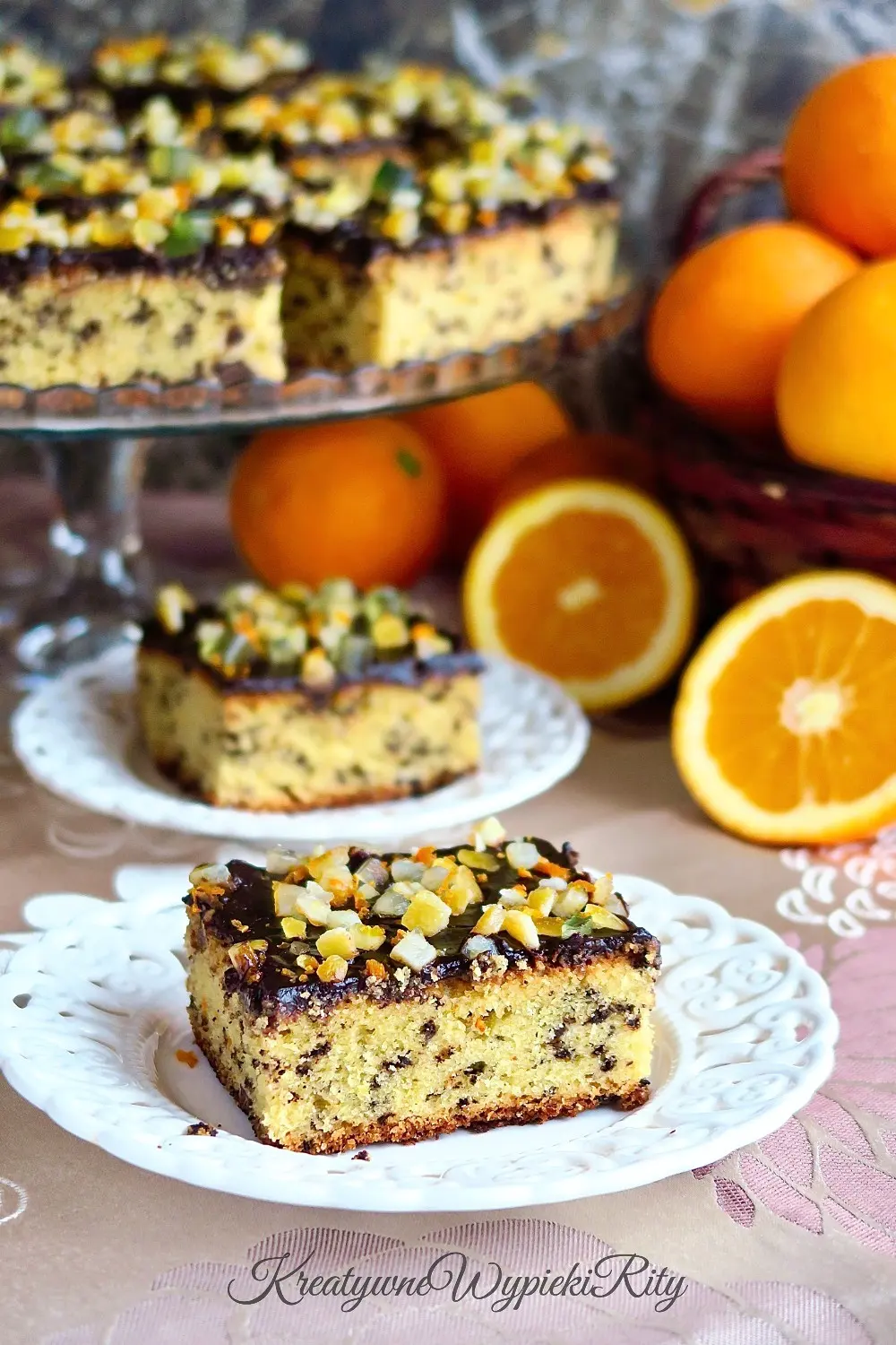 Wegańskie ciasto pomarańczowo czekoladowe polane lśniącą polewą kakaową.