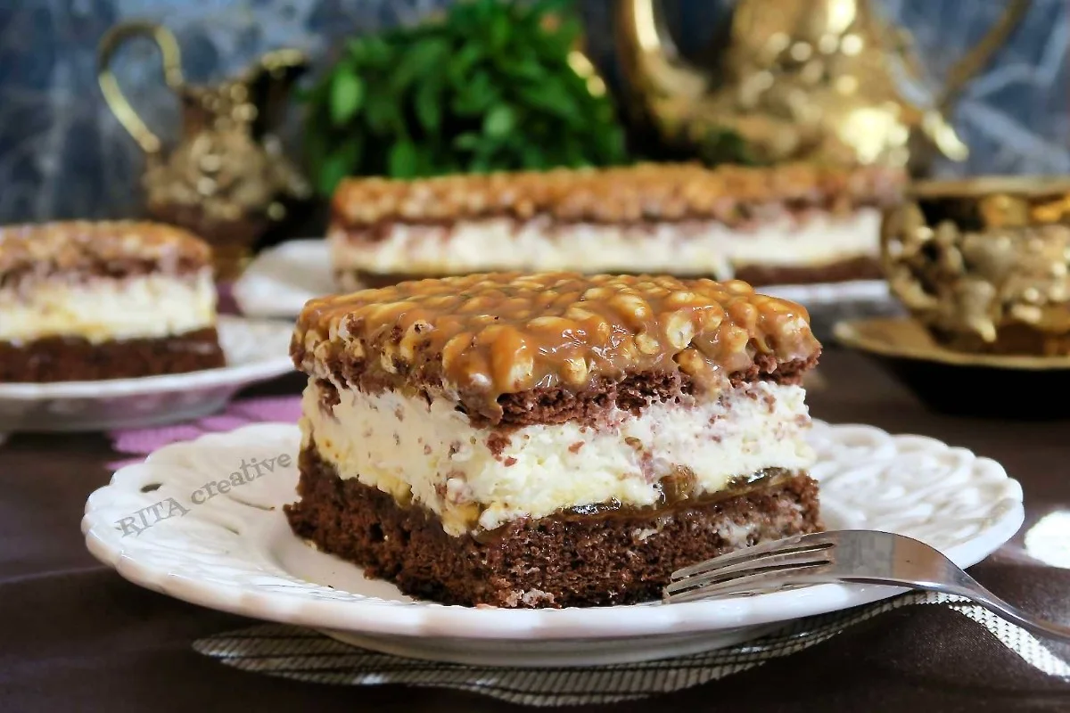 Ciasto Szyszkowy Król serwowane na talerzyku, ukazujące wilgotny biszkopt, gęsty krem i dekorację z ryżu preparowanego.