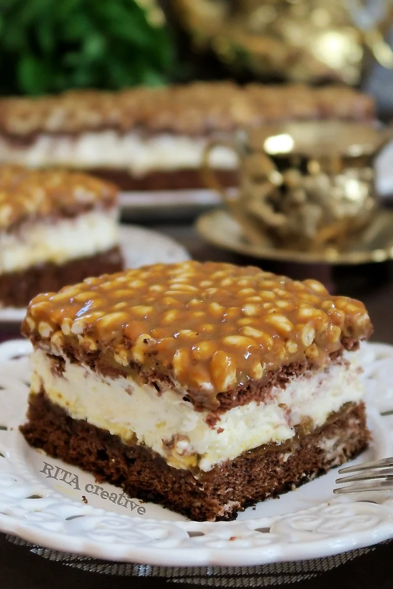 Pokrojone w kostkę ciasto Szyszkowy Król na paterze obok filiżanki kawy. W tle delikatne dekoracje świąteczne.