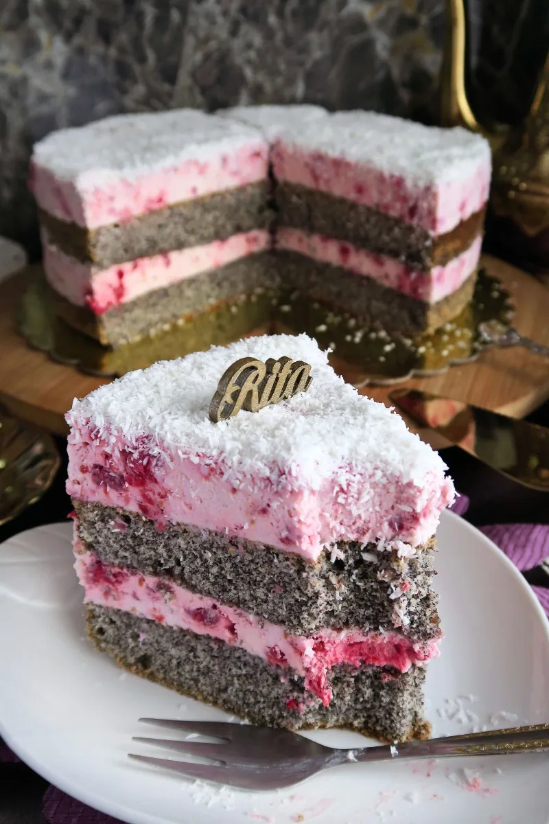 Kawałek wilgotnego ciasta z makiem na talerzyku, widoczne warstwy kremu mascarpone i malin.