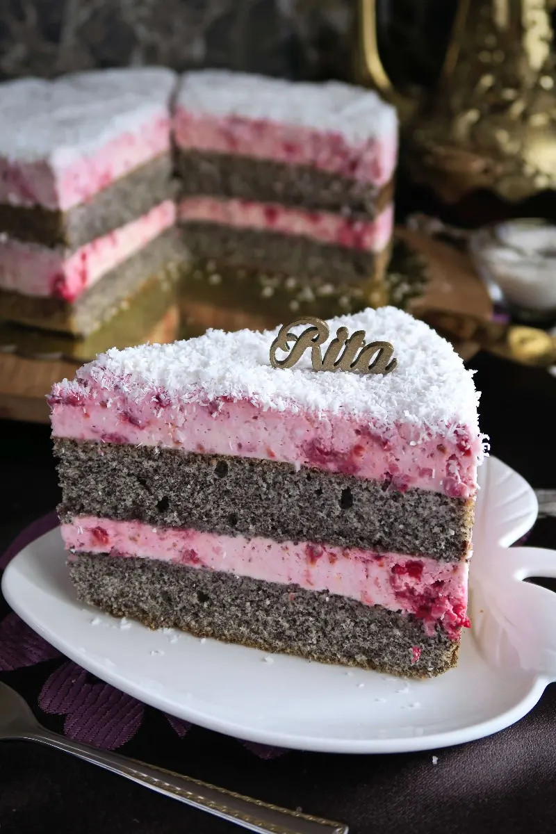 Kawałek wilgotnego ciasta z makiem na talerzyku, widoczne warstwy kremu mascarpone i malin.