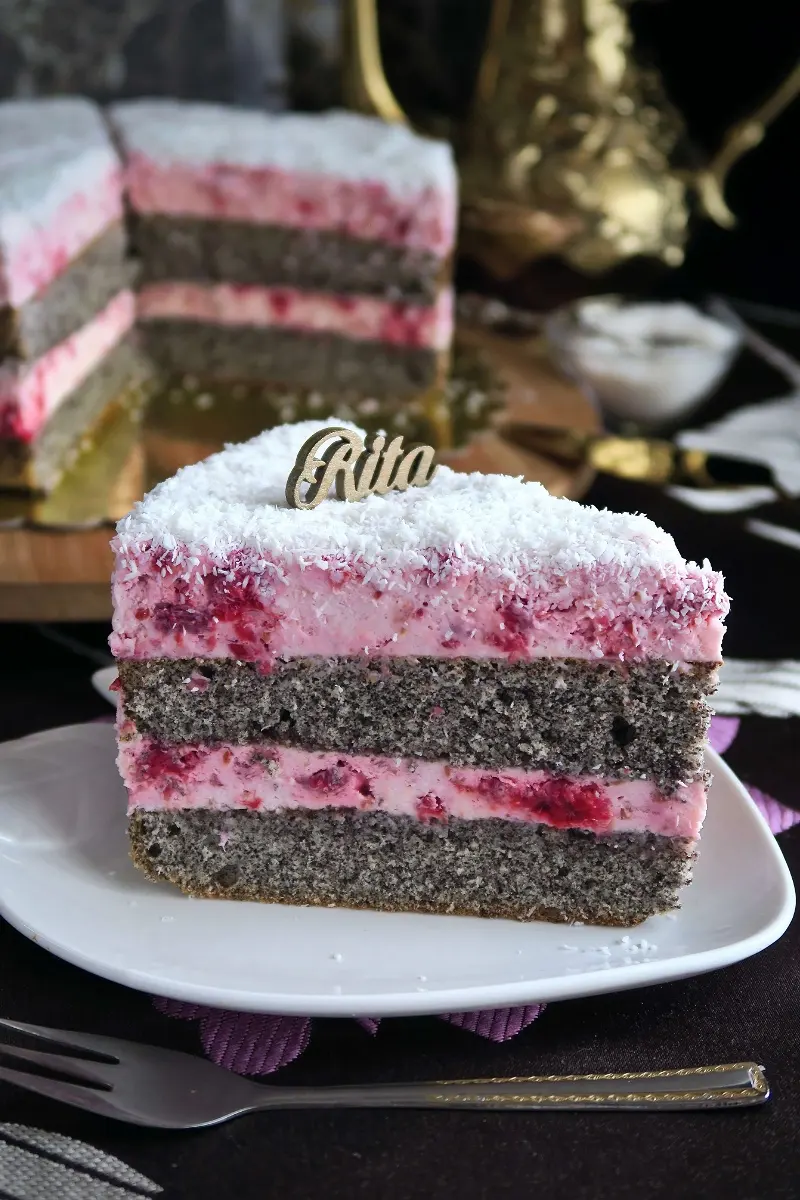 Torcik makowy z malinami posypany wiórkami kokosowymi.