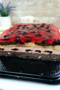 Makowiec z wiśniami w prostokątnej formie pokryty błyszczącą galaretką wiśniową z całymi owocami, idealne ciasto makowe z wiśniami na święta