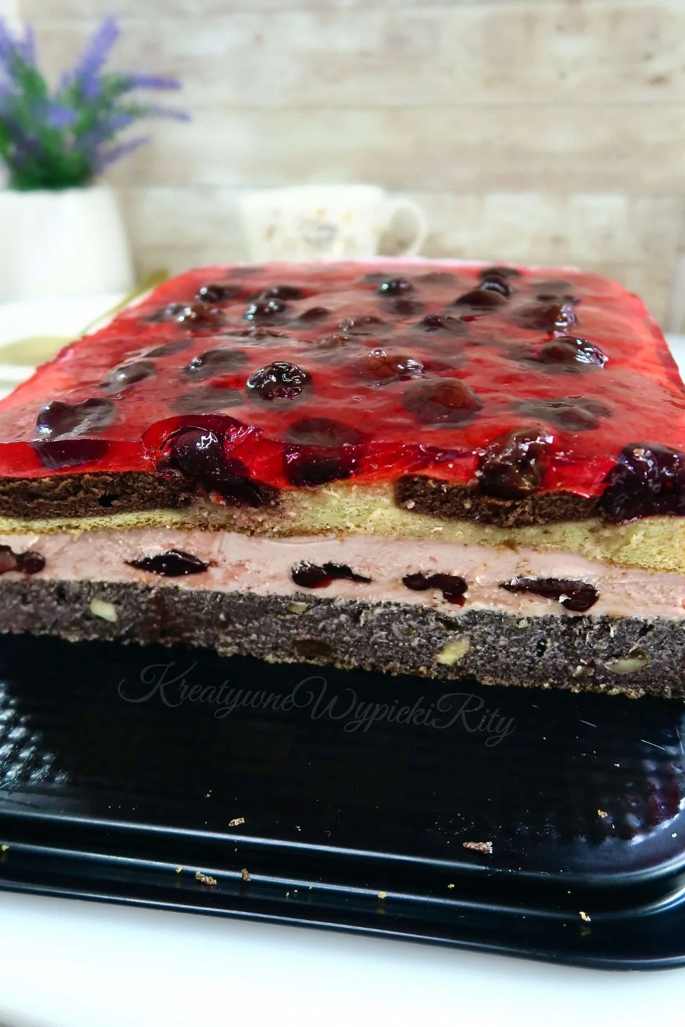 Makowiec z wiśniami w prostokątnej formie pokryty błyszczącą galaretką wiśniową z całymi owocami, idealne ciasto makowe z wiśniami na święta